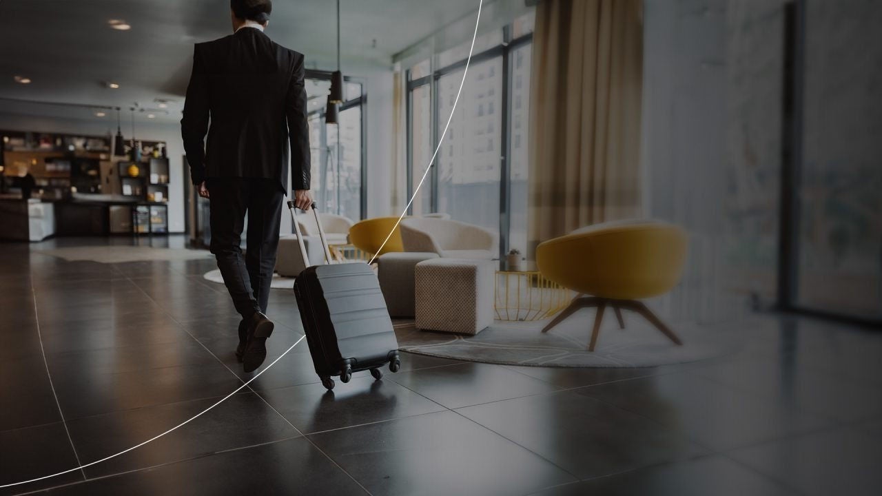 איש עסקים עם מזוודה הולך בבאנר שולחן עבודה של שדה התעופה.