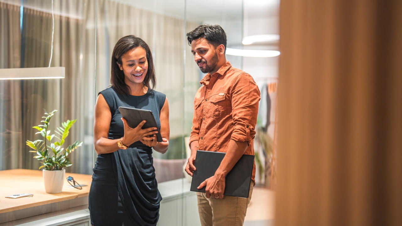 Twee collega's kijken naar een digitale tablet