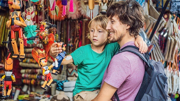 Father carrying son in marketplace