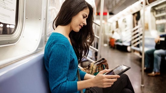 Žena gleda tablet u metrou