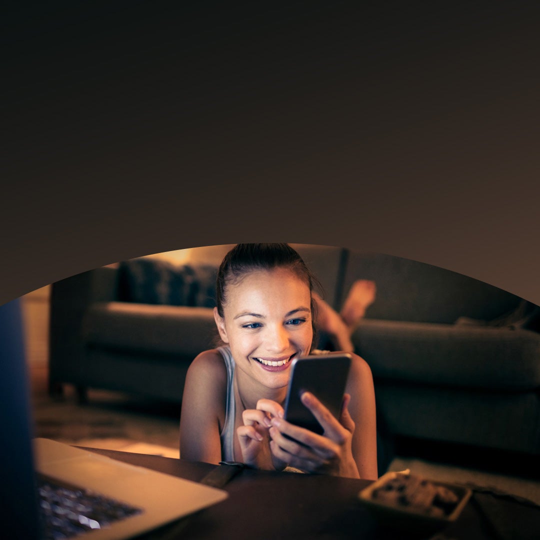 Woman smiling using her phone.
