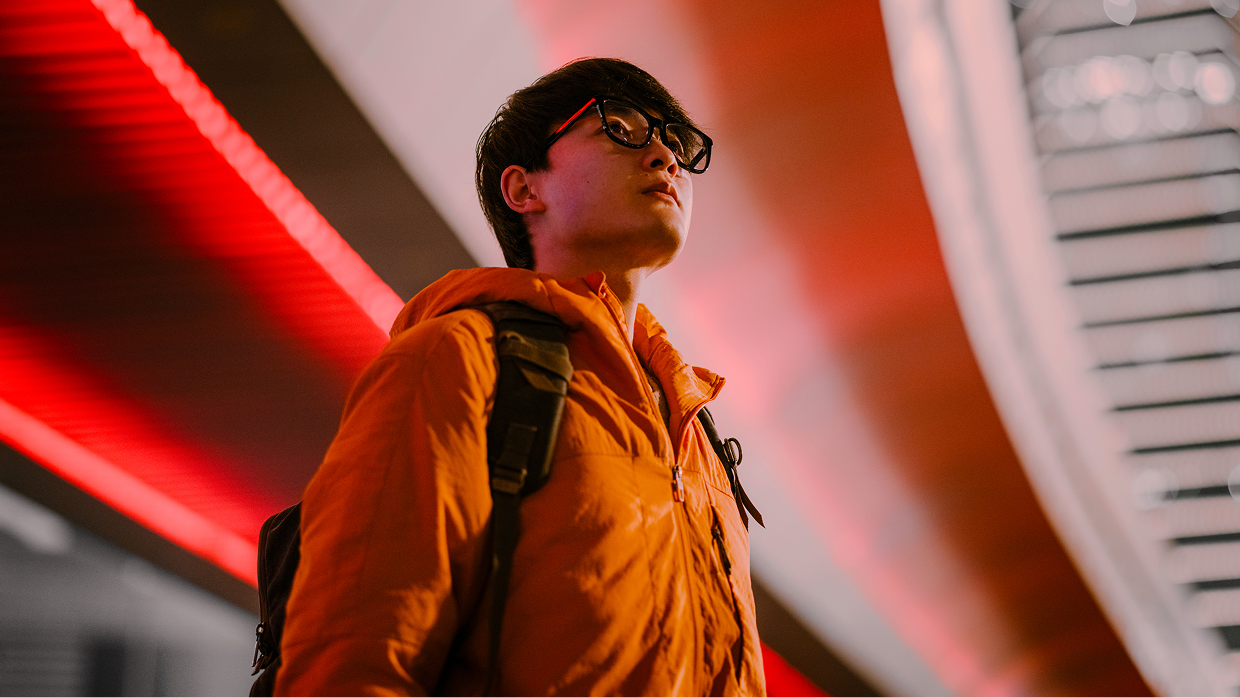 Man in orange jacket wearing glasses