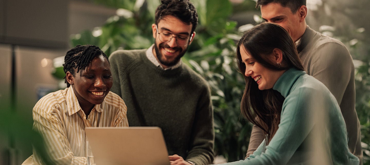 People gathered around a laptop on a table
