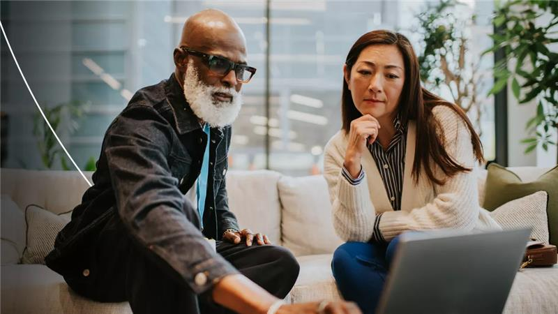 Man en vrouw kijken naar laptop