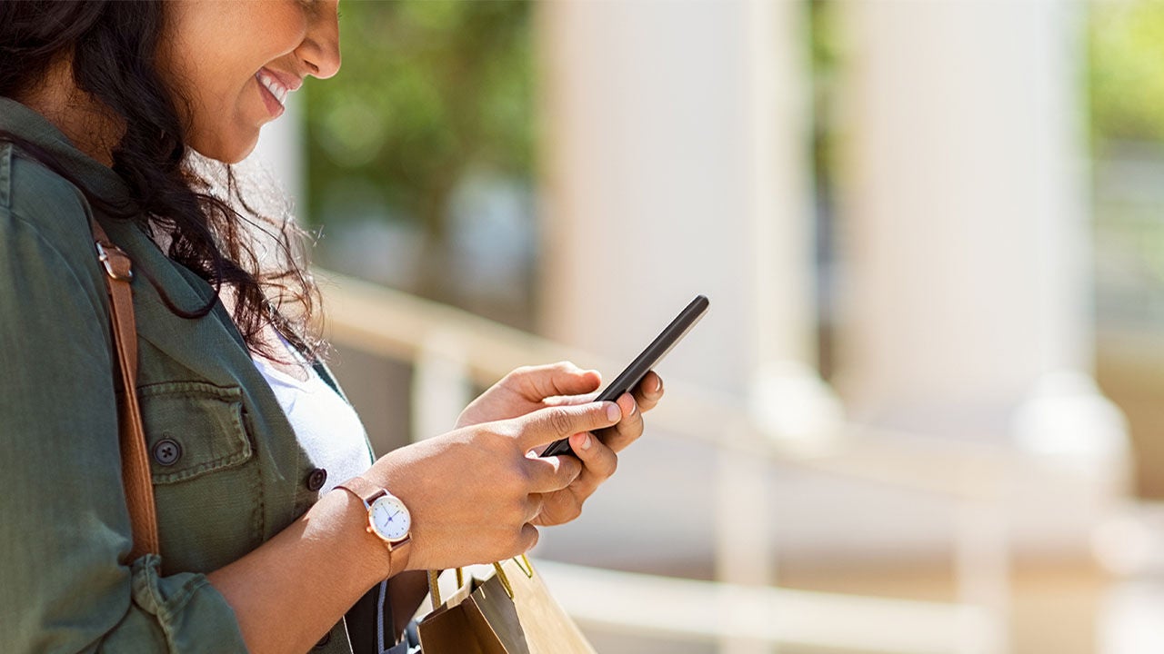 Smiling girl using phone.
