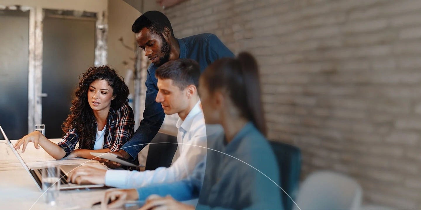 مجموعة من الأشخاص يعملون ويتعاونون حول حاسوب محمول.