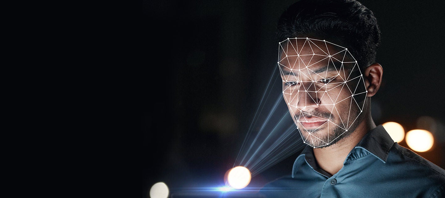 A man is illuminated by a soft, glowing light, creating a striking contrast against the dark background.