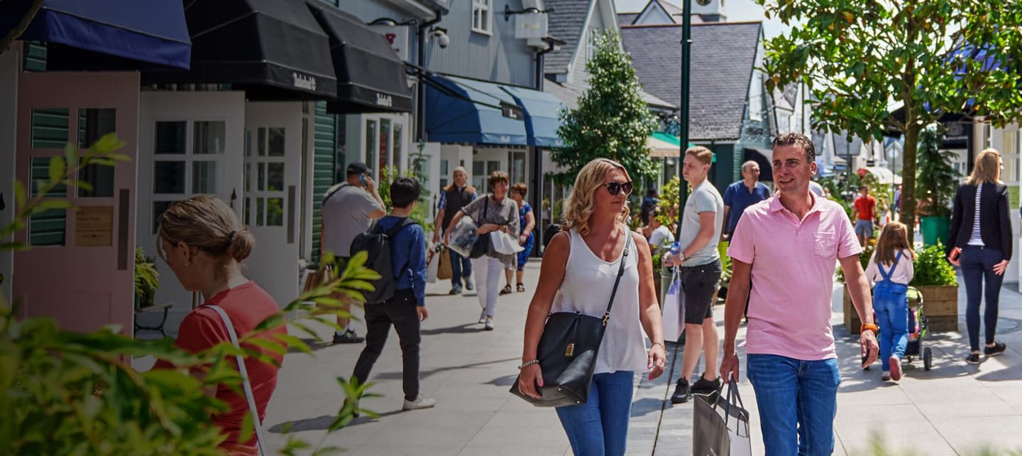 people shopping at outdoor designer outlet mall