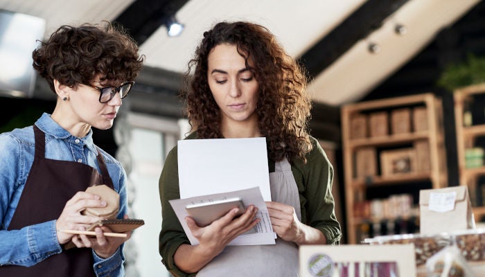 Two women reviewing stock at a store
