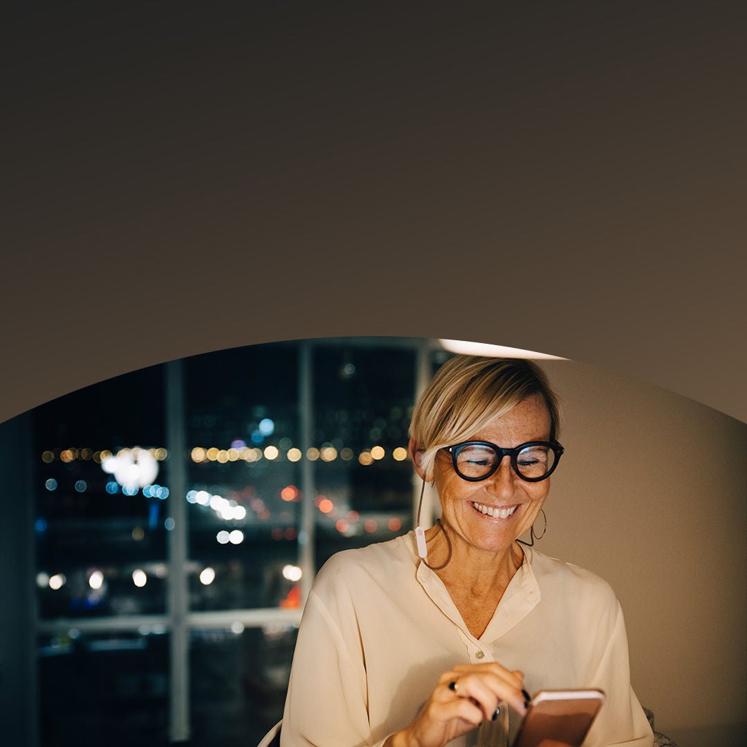 Small business owner smiling looking at her phone.