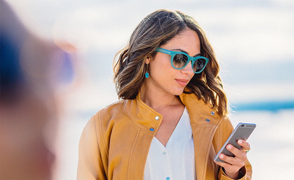 Woman with green glasses using her phone