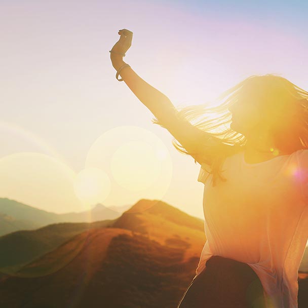 Person outside enjoying nature and expressing joy.