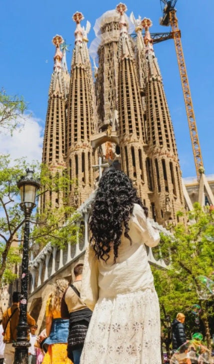A woman takes a photo of La Sagrada Familia