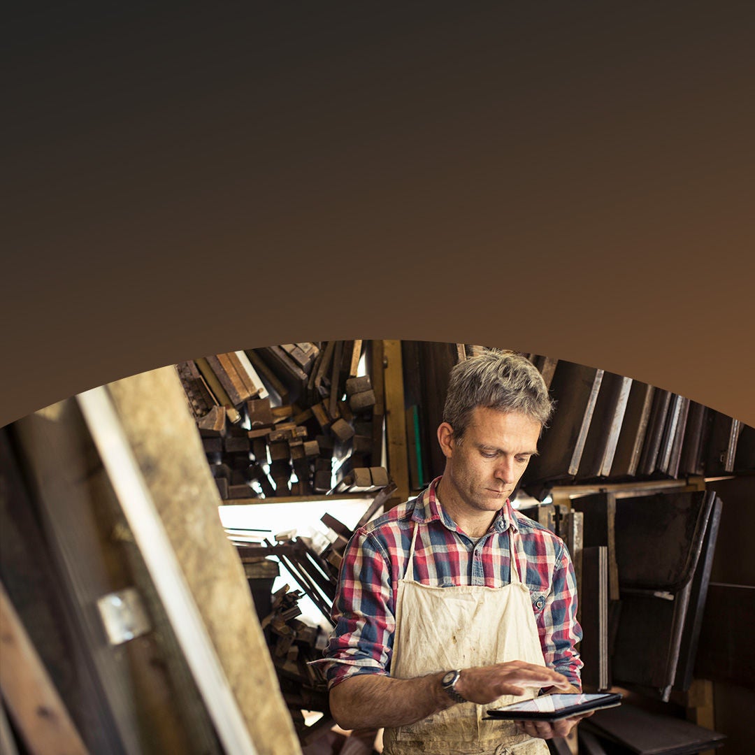 Woodshop worker using tablet in his shop. 