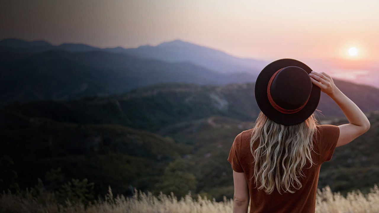 Woman overlooking sunset in the mountains.