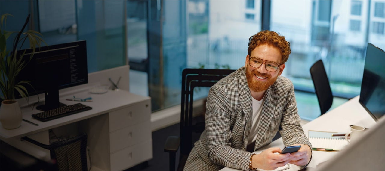 smiling redheaded man using phone