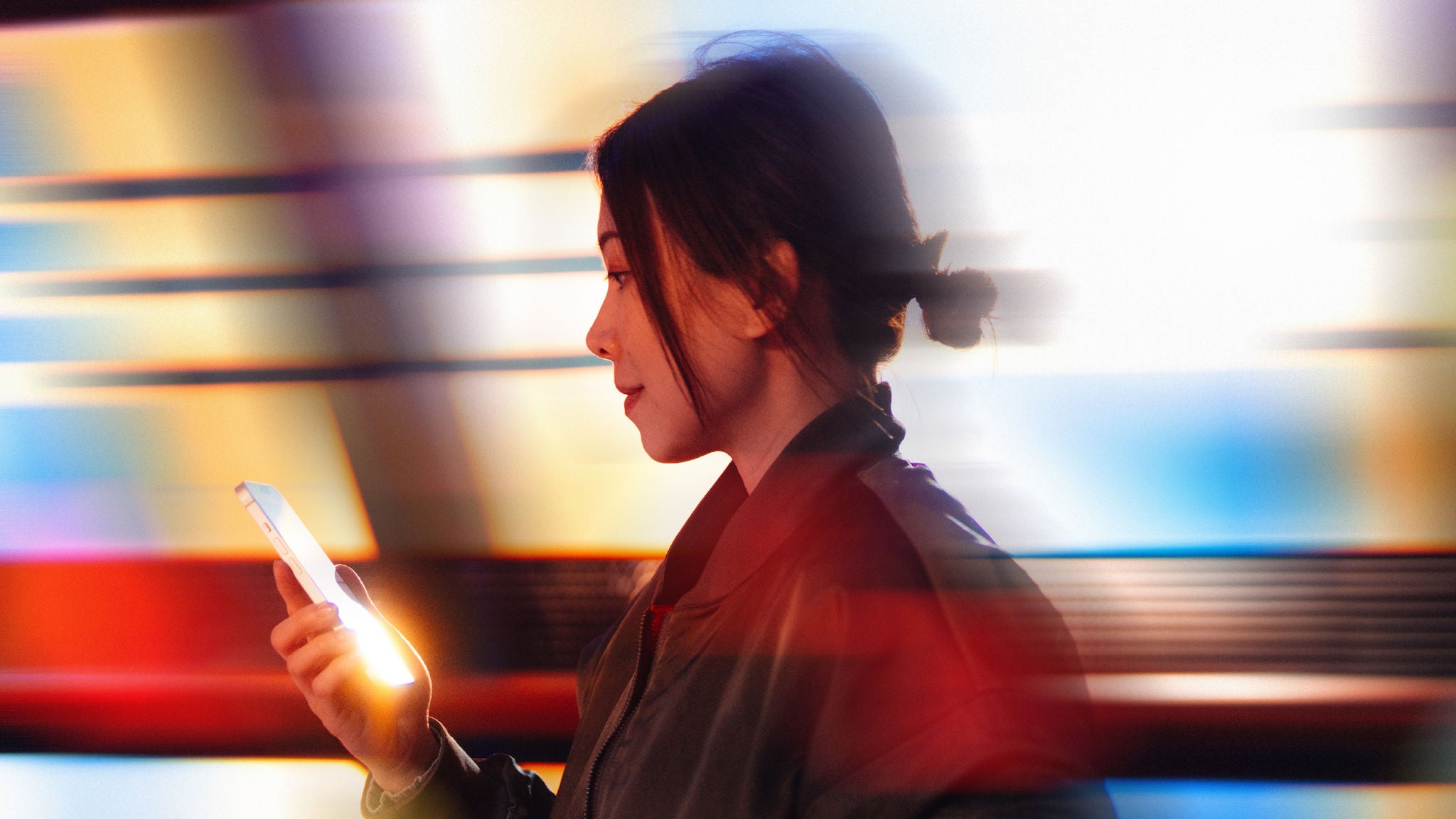 Blurry side profile of a woman on an iphone