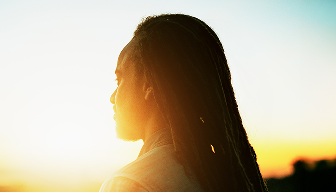 Two coworkers smiling while looking at a tablet together.
