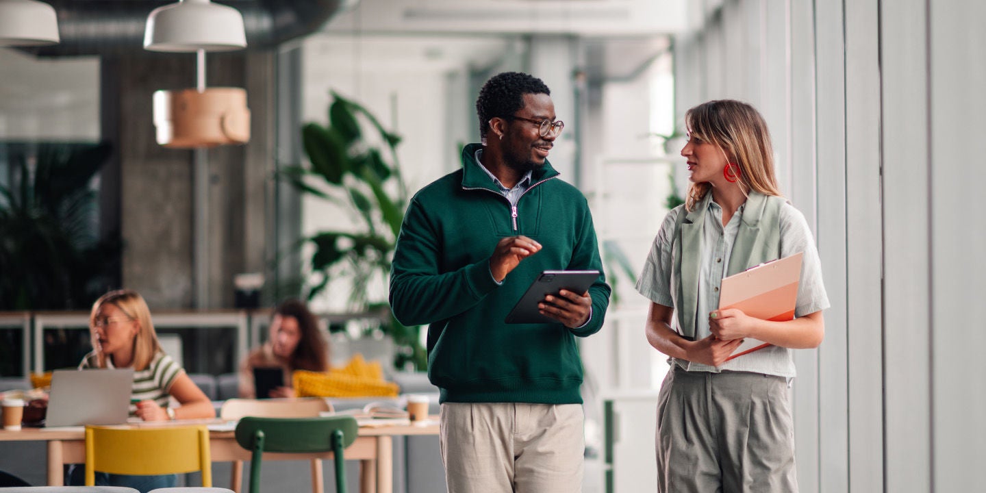 A man and a woman discussing work at the office