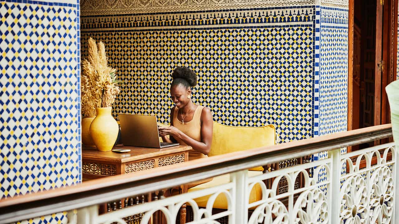 smiling woman sitting at tiled balcony table