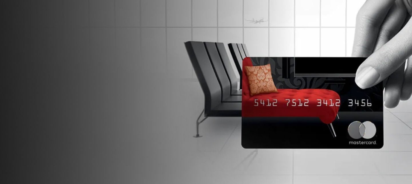 hand holding credit card at airport terminal