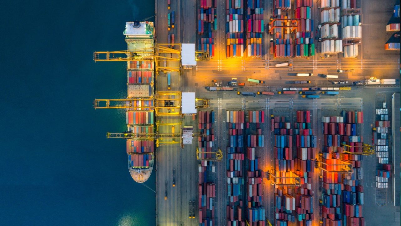 A cargo ship at a dock unloading or loading containers. 