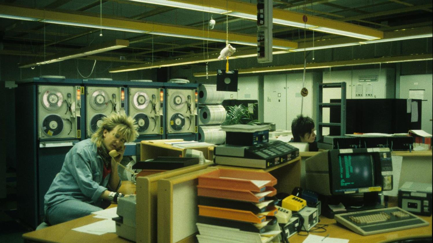 Woman working with old tape machines