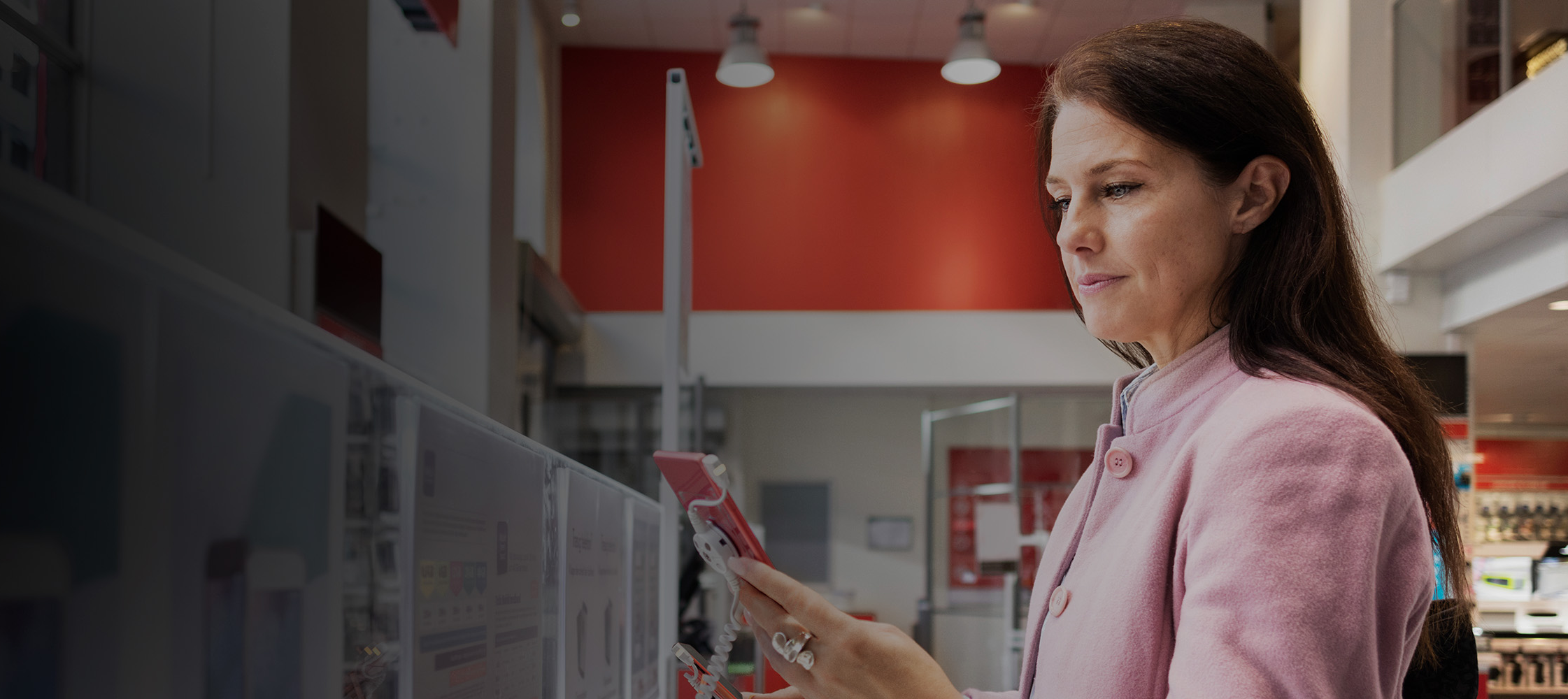 Woman looking at phones at a telecommunications store