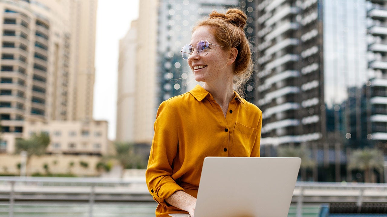 Young woman sitting in marina aria and working on a laptop