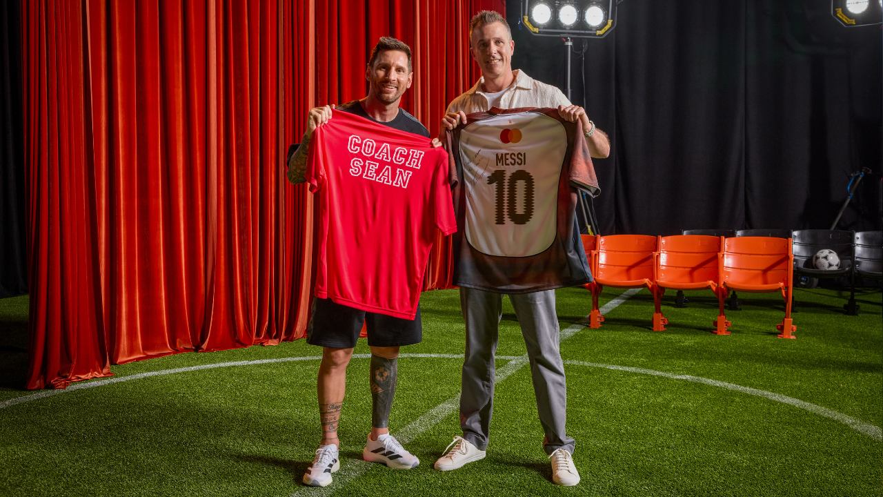 Lionel Messi and Sean Doherty hold up their jerseys. 