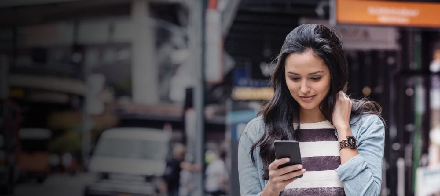 žena se dívá na chytrý telefon na městské ulici