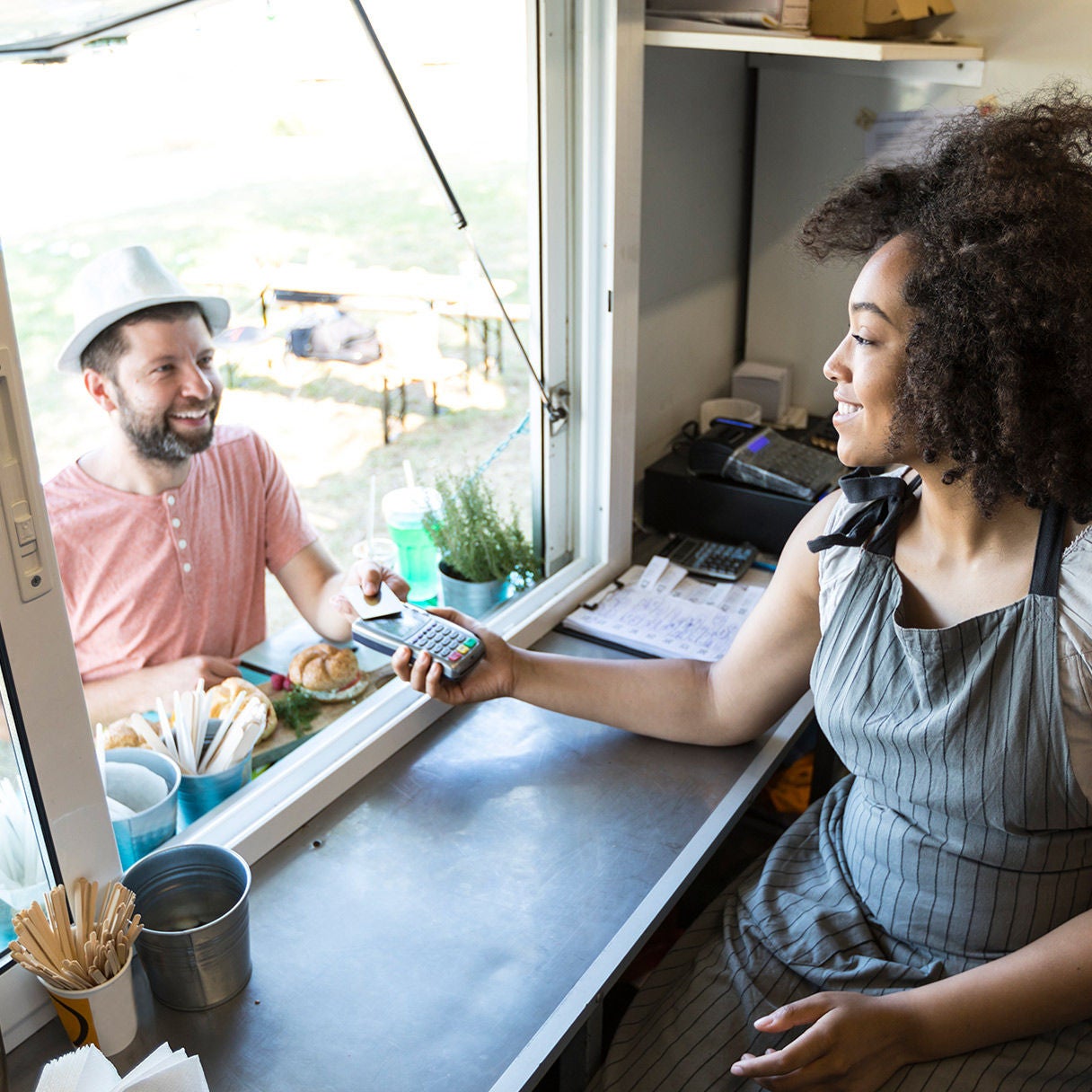 Woman taking payment from food truck.