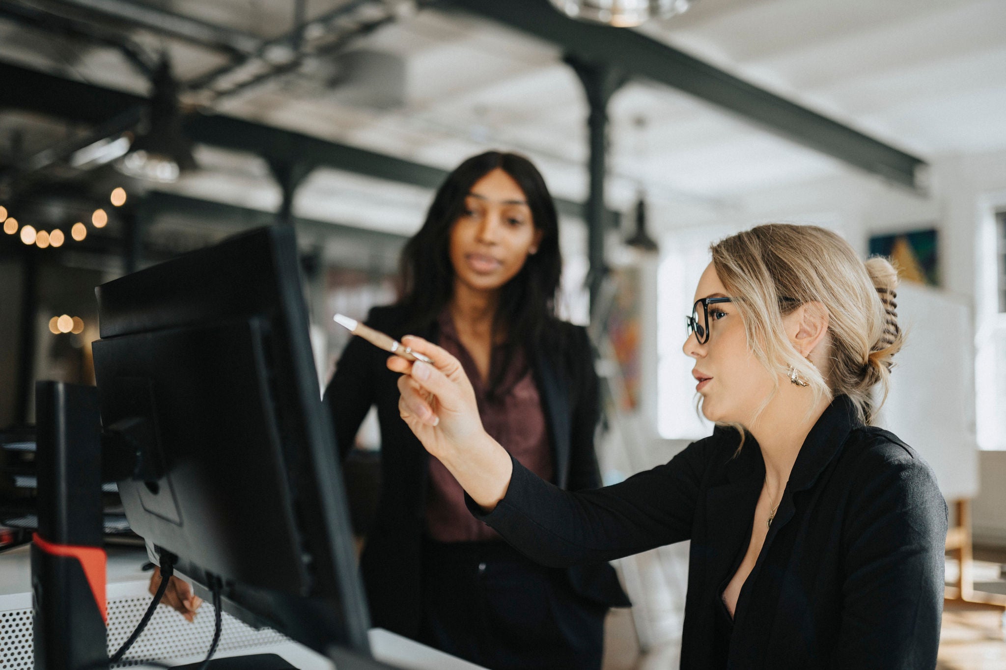 Two women discussing cybersecurity on the computer