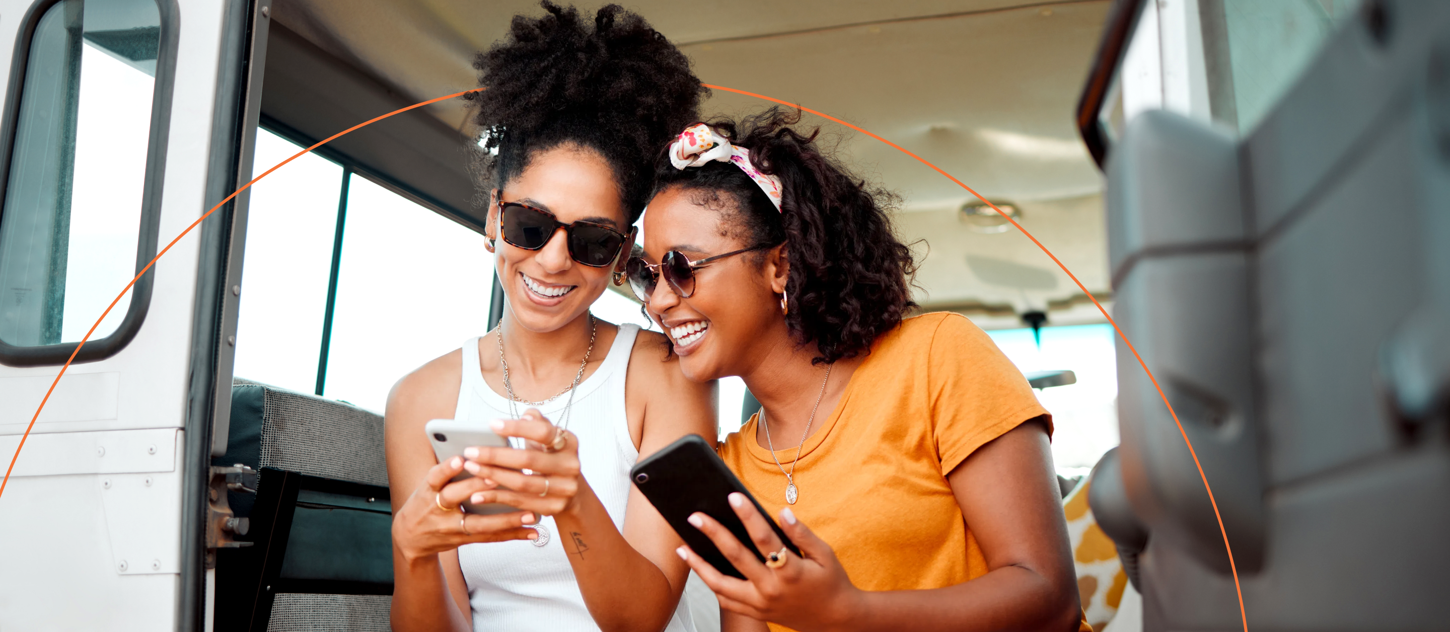 Two women in a van looking at their phone