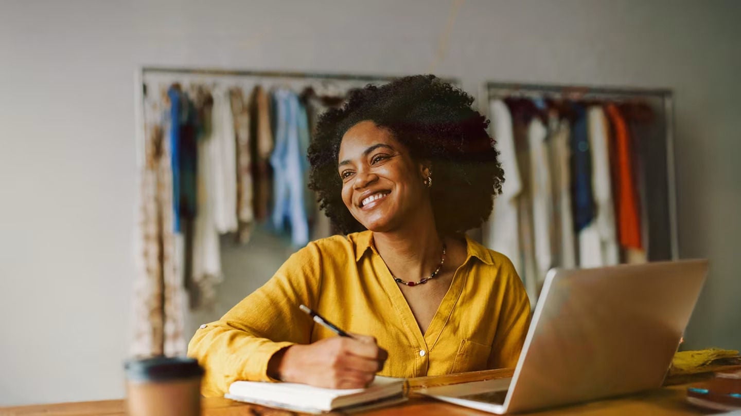 Mosolygó nő dolgozik laptopon