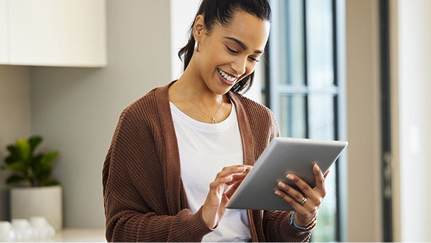 Woman looking at ipad smiling