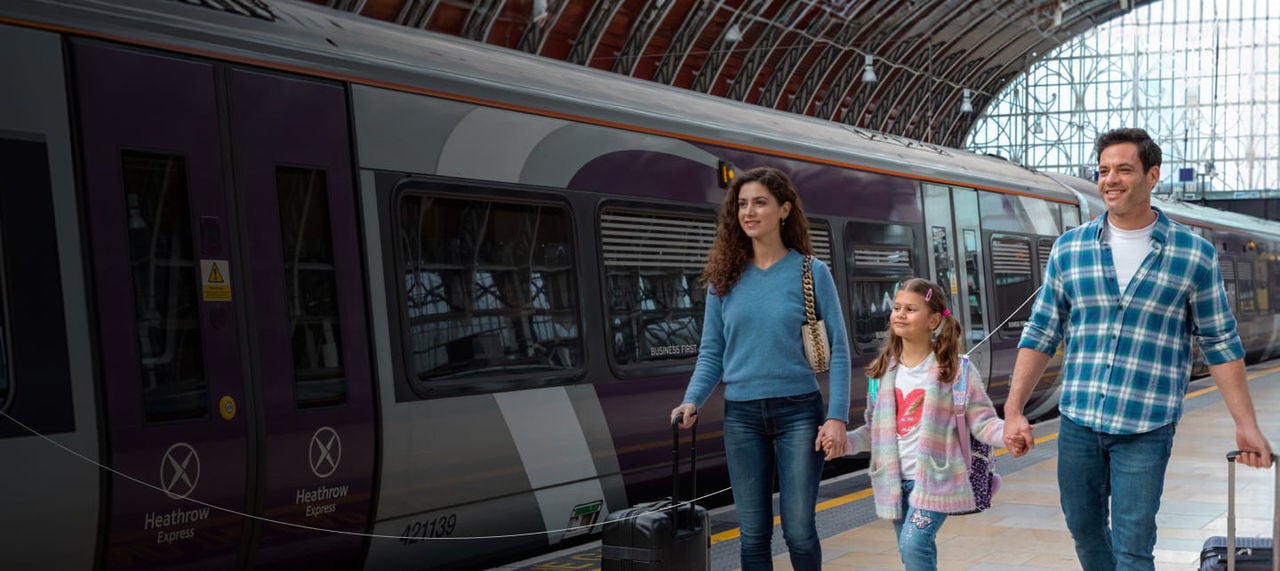 couple stepping off heathrow express train at station