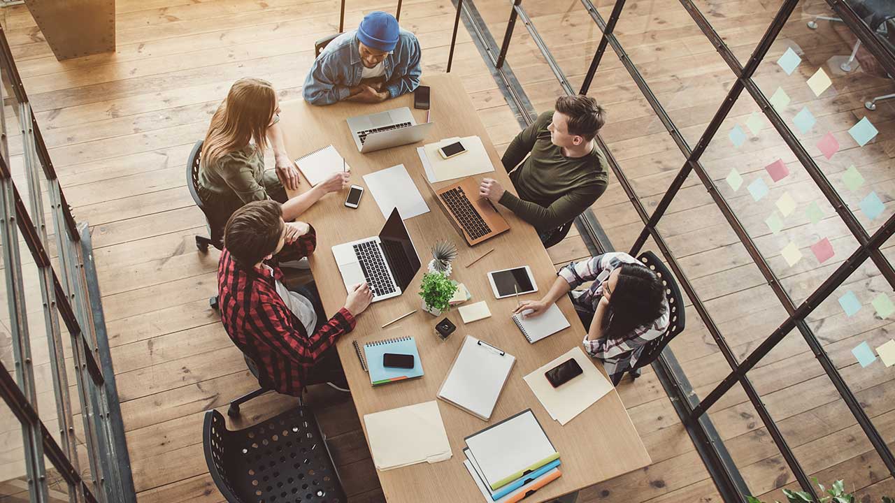 Aerial view of colleagues working in meeting room.