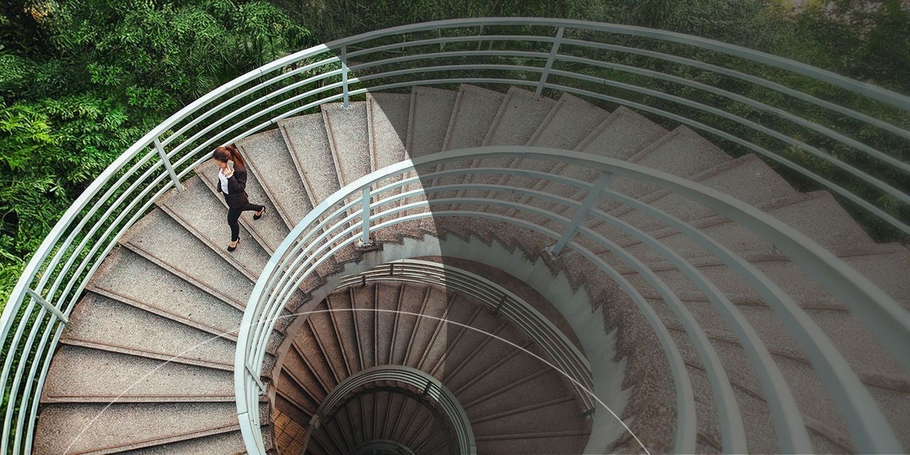 אדם יורד במדרגות לולייניות, ומציג לראווה את הקימורים האלגנטיים של המדרגות ואת האדריכלות שמסביב.