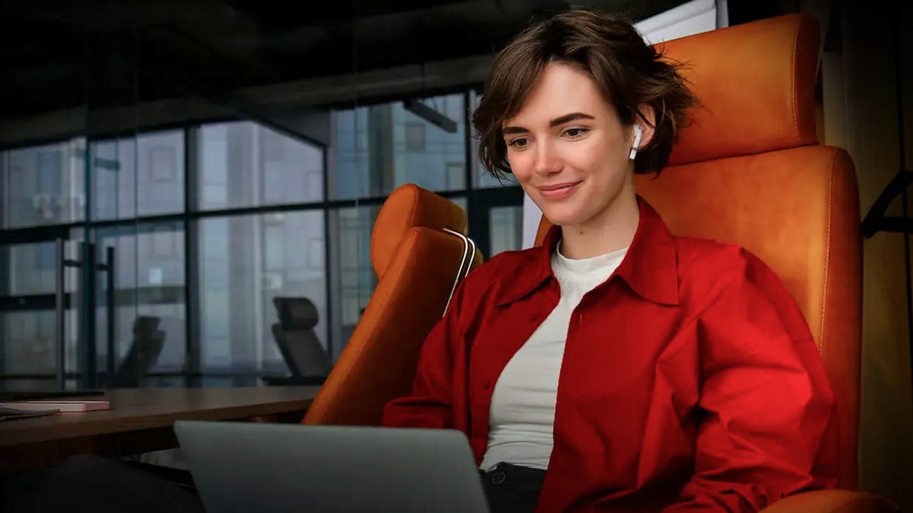 woman using laptop in orange chair