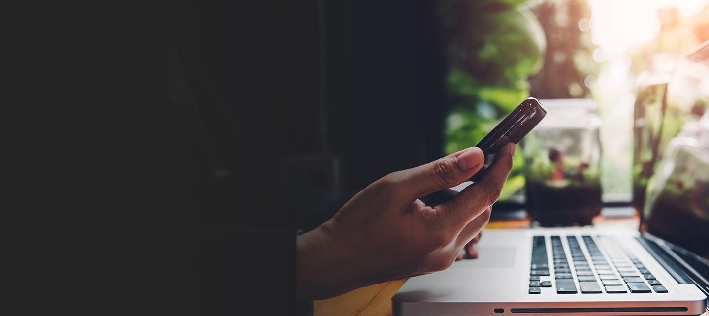 Laptop and phone on a cafe's table.