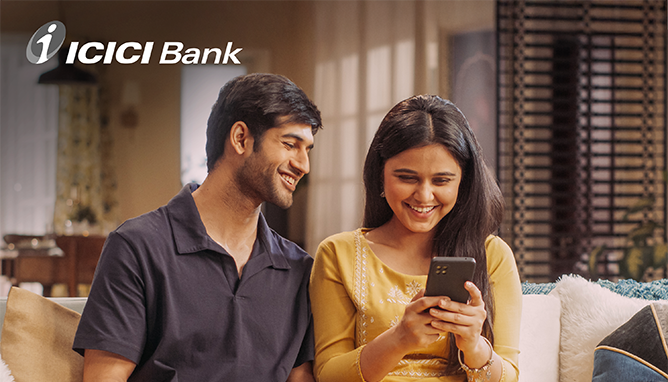 Mann und Frau schauen auf ein Telefon mit dem ICICI-Banklogo in der Ecke.