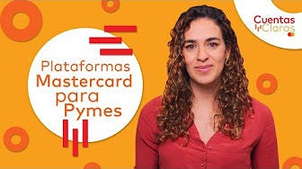 A man and a woman are seated at a desk in an office, working intently on a laptop.