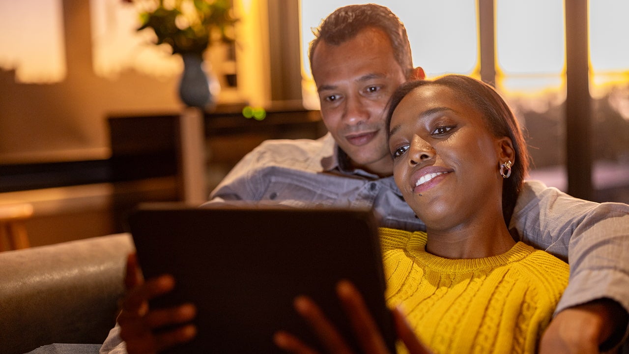 happy couple watching video on a tablet