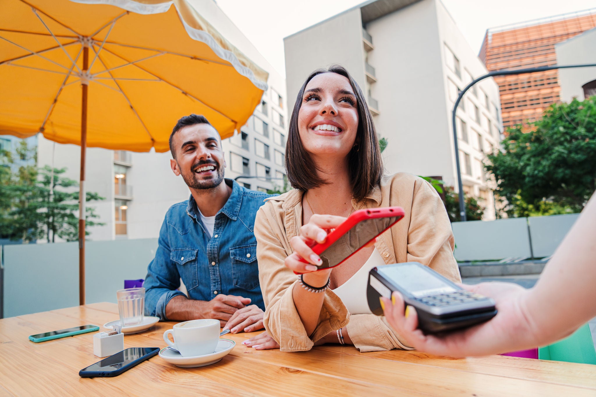 Ženska osoba plaća mobilnim telefonom.
