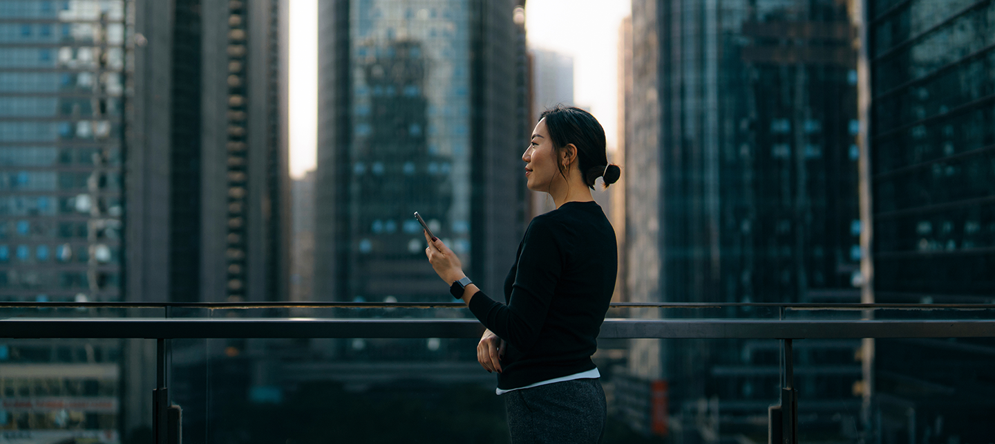 Woman on phone in front of skyscrapers