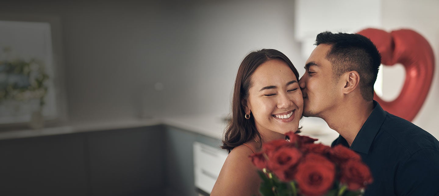 Man kissing a woman's cheek.
