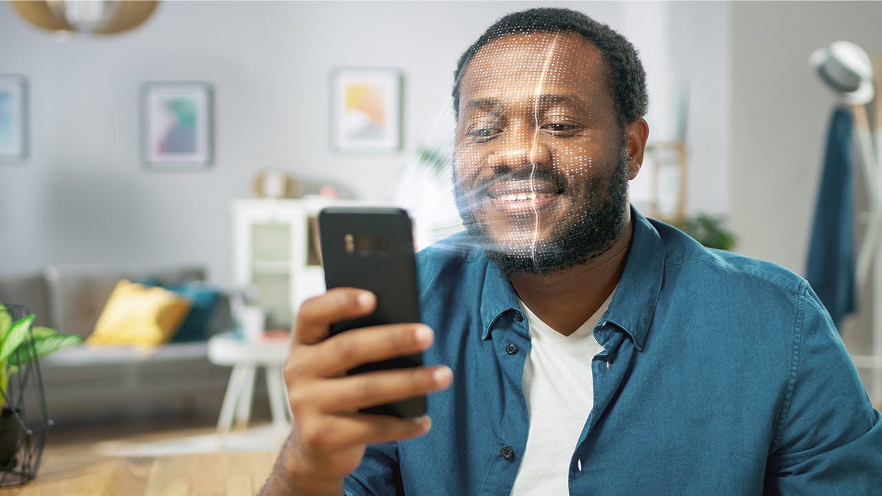 man identified by biometric facial recognition scanning process from his smartphone