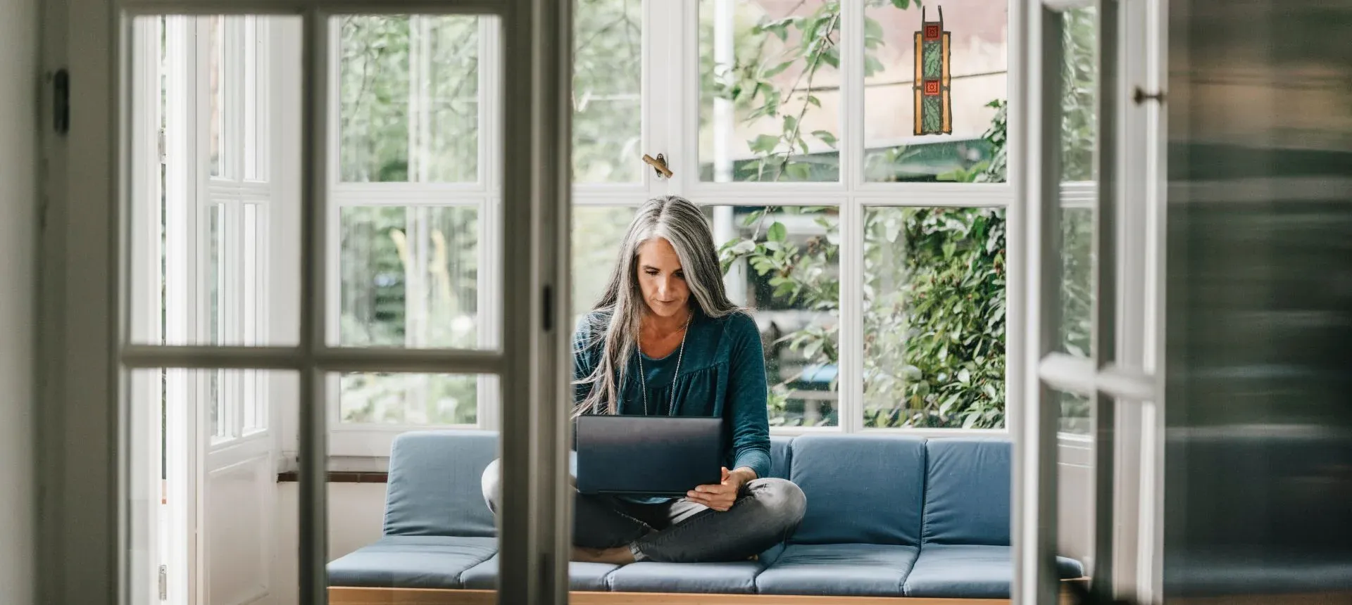 Woman on couch looking at laptop