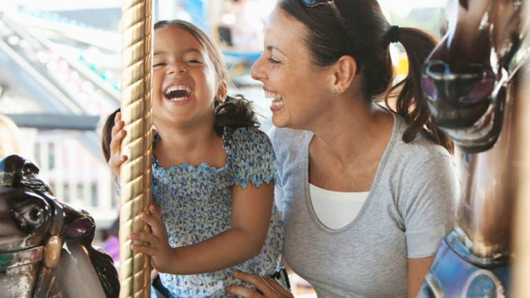 mom and her daughter playing carousel